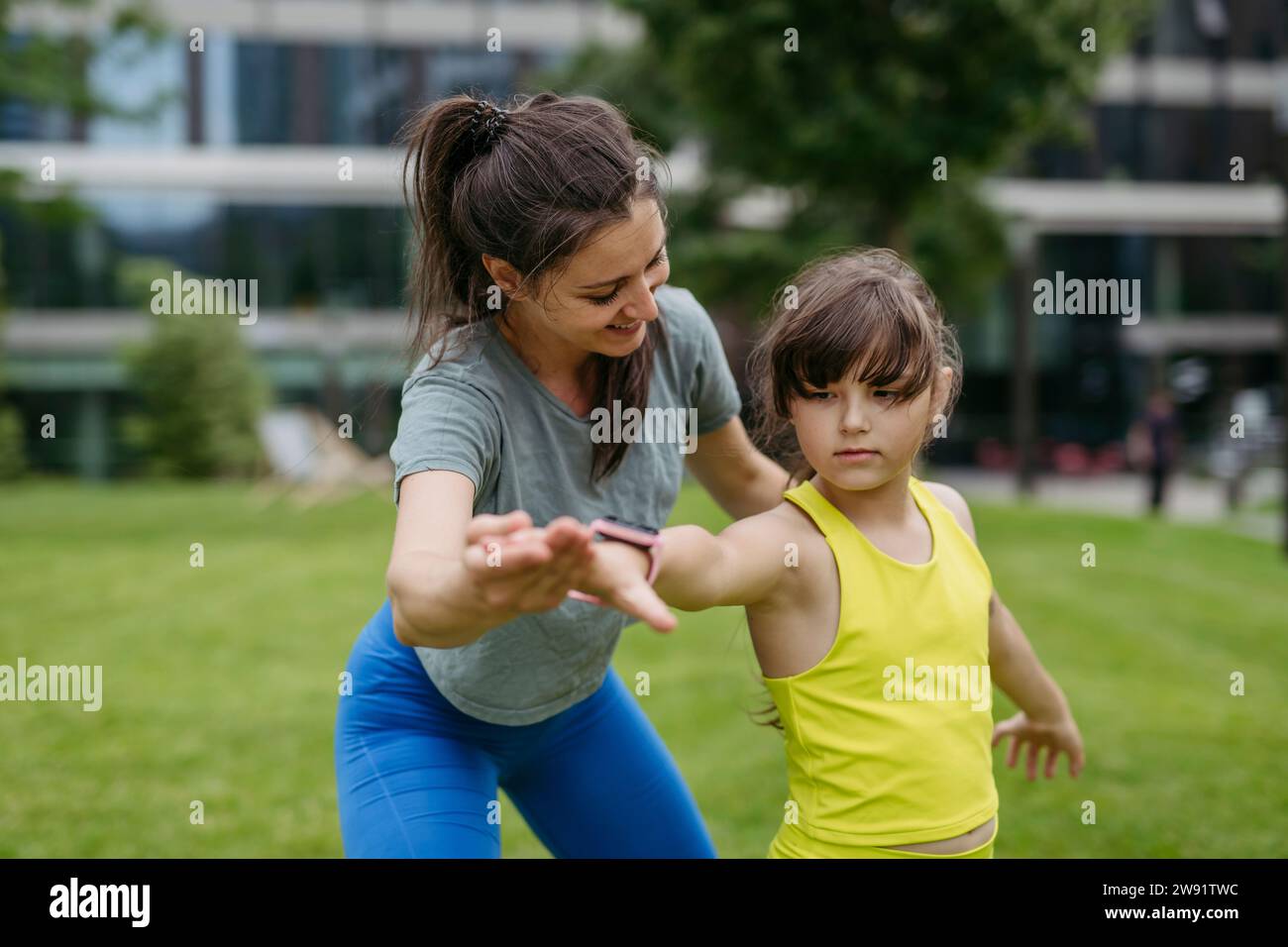 Mother and daughter spending together time outdoors practicing yoga Stock Photo