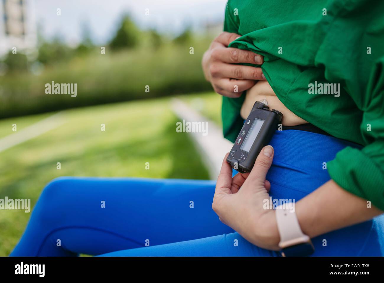 Woman with diabetes exercises outdoors in the city, checking her blood