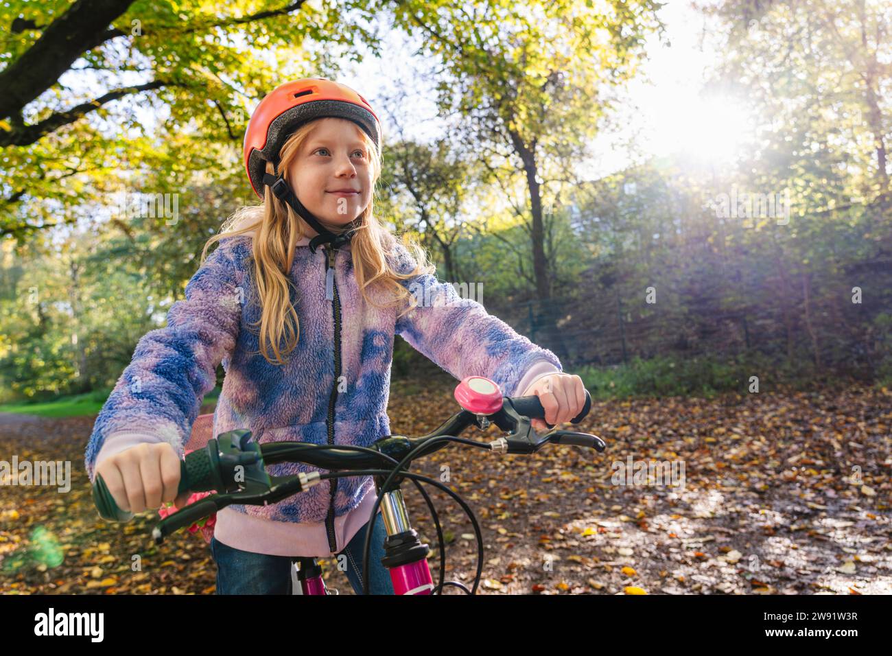 Girl cycling at park on sunny day Stock Photo