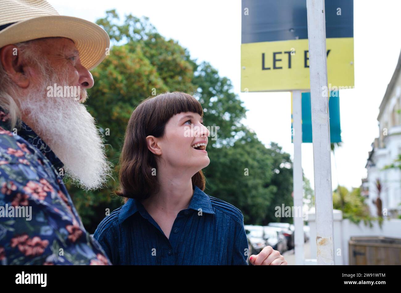 Happy father and daughter standing near sign board Stock Photo - Alamy