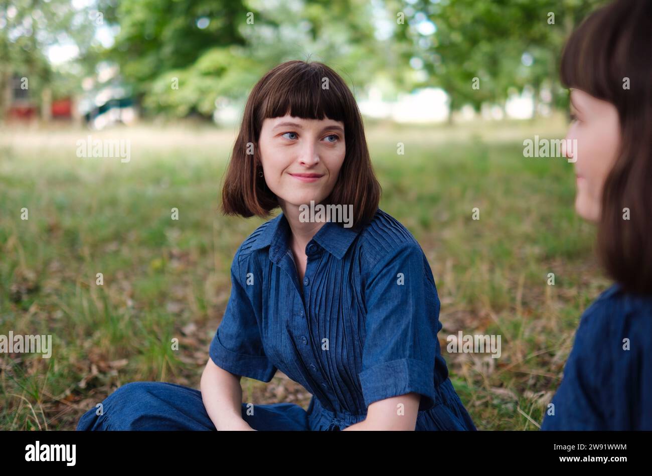 Smiling young woman looking at sister in park Stock Photo