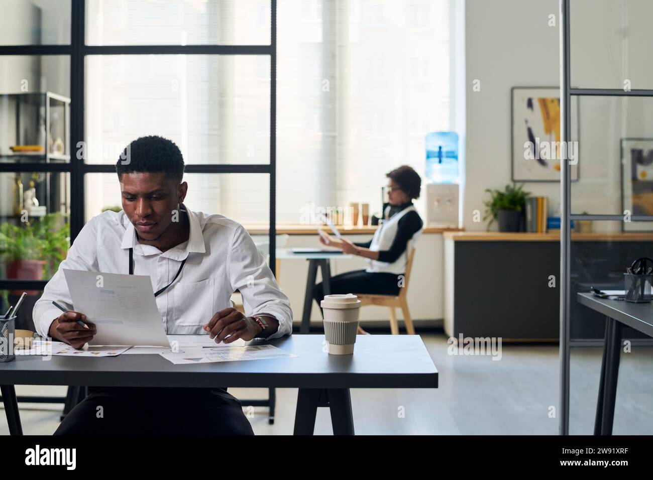 Young businessman reading documents at desk in office Stock Photo