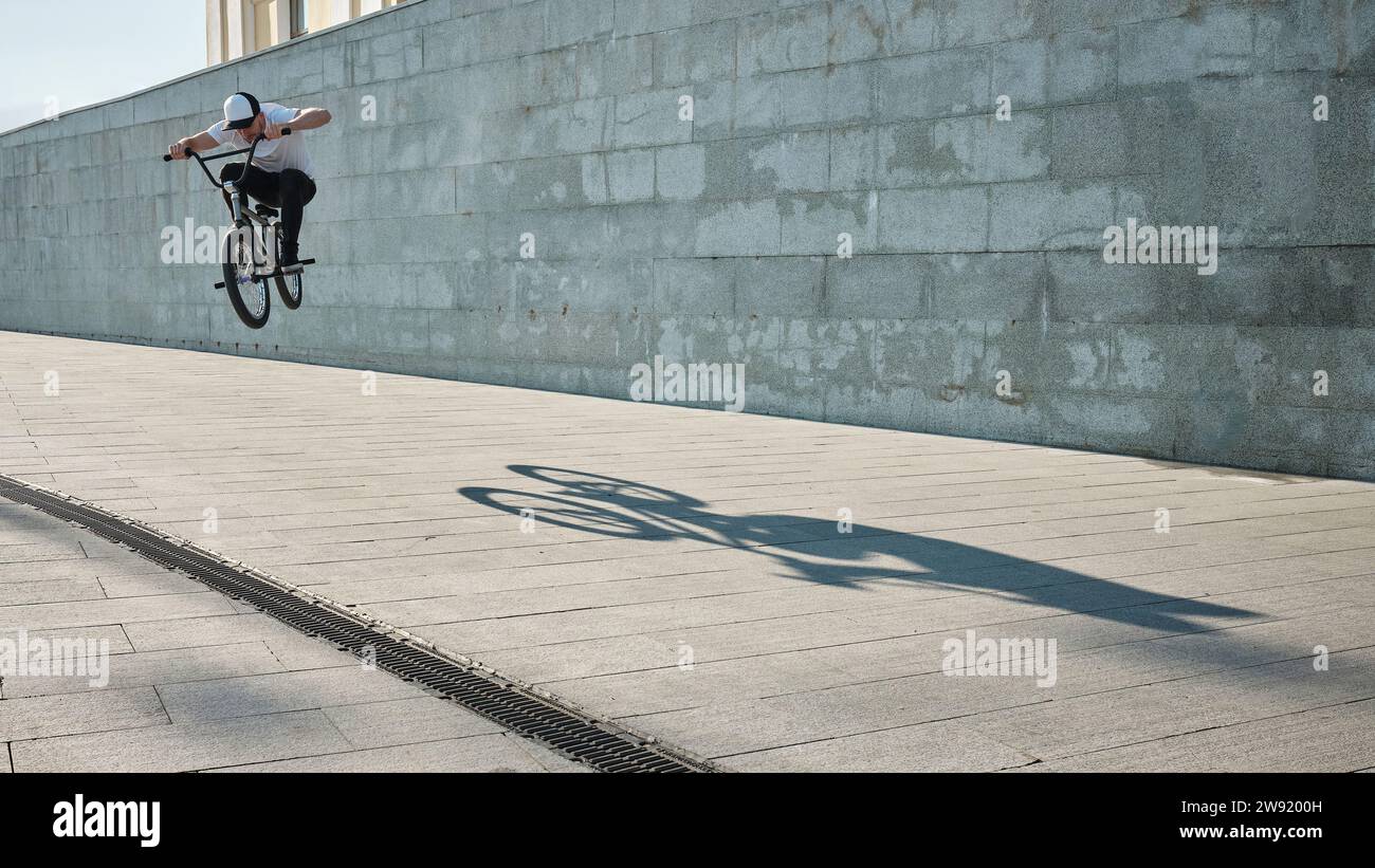 Man doing stunt with BMX bike in front of wall Stock Photo