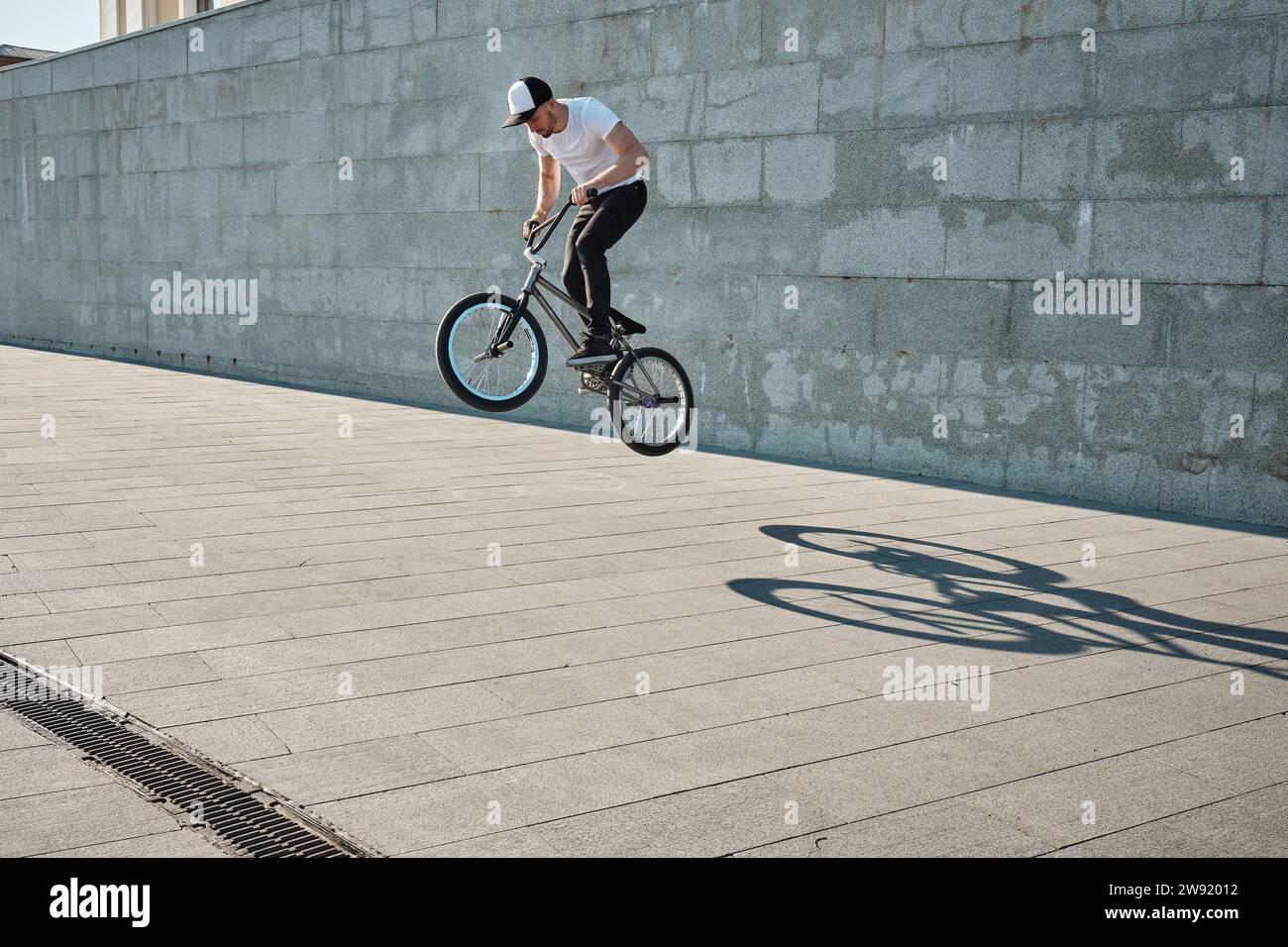 Man doing stunt with BMX bike near wall Stock Photo