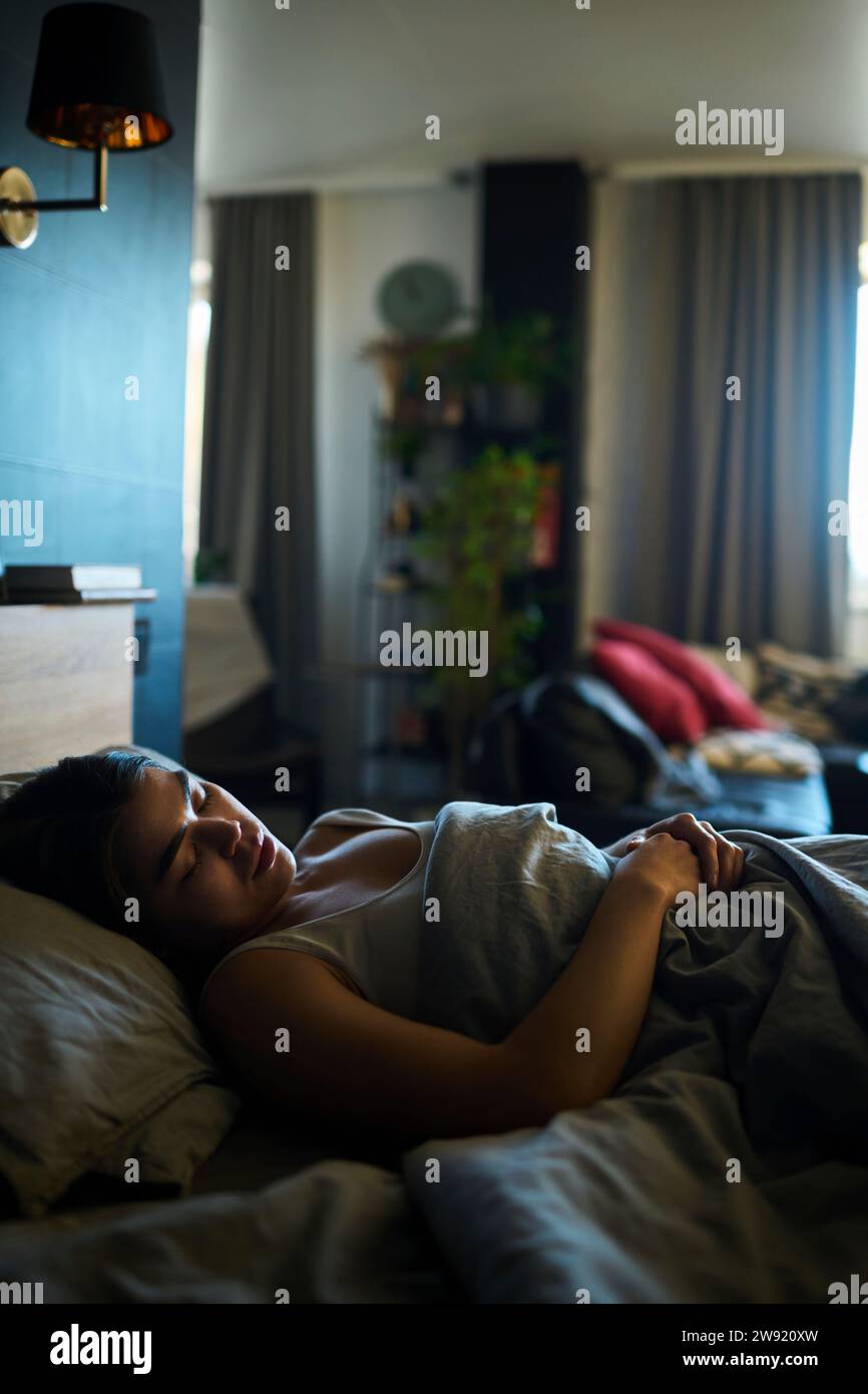Woman sleeping on bed at home Stock Photo
