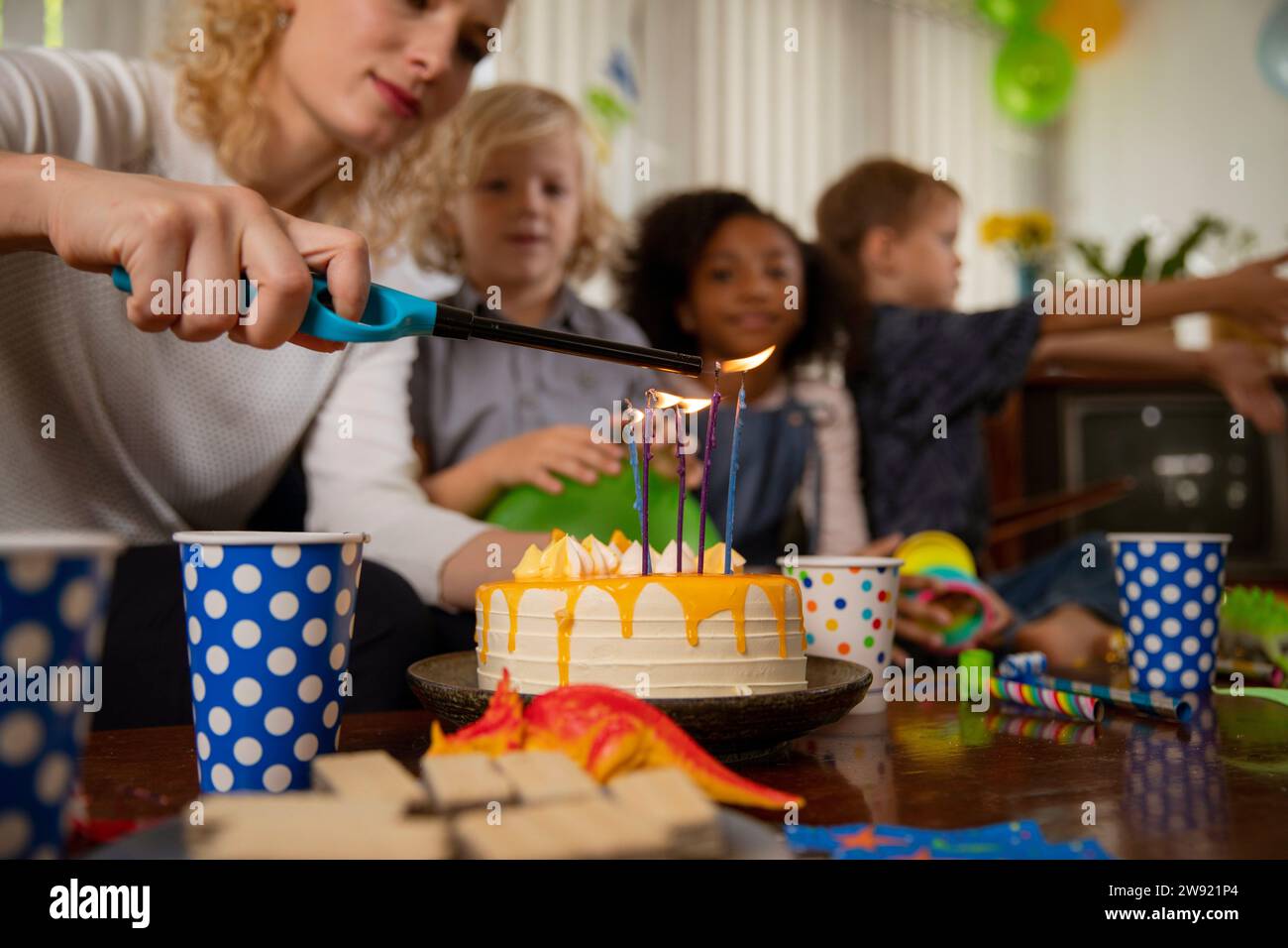 Woman lighting candles on birthday cake at home Stock Photo - Alamy