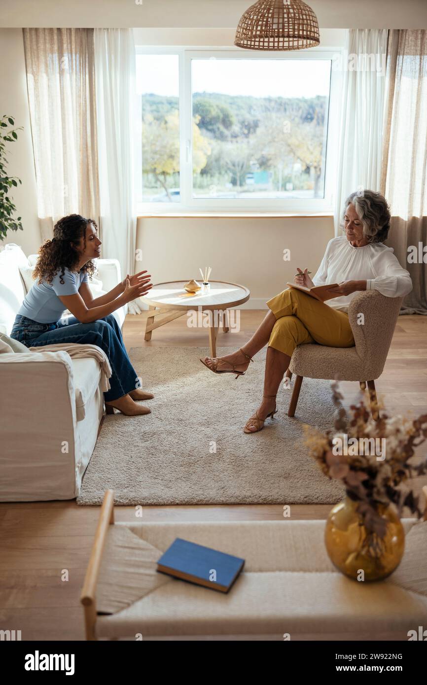 Woman having counseling session with psychotherapist at home Stock Photo