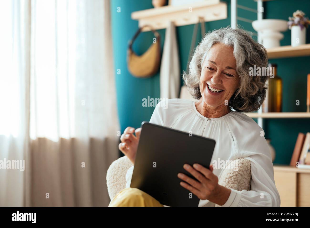Happy psychologist using tablet PC and sitting at home Stock Photo