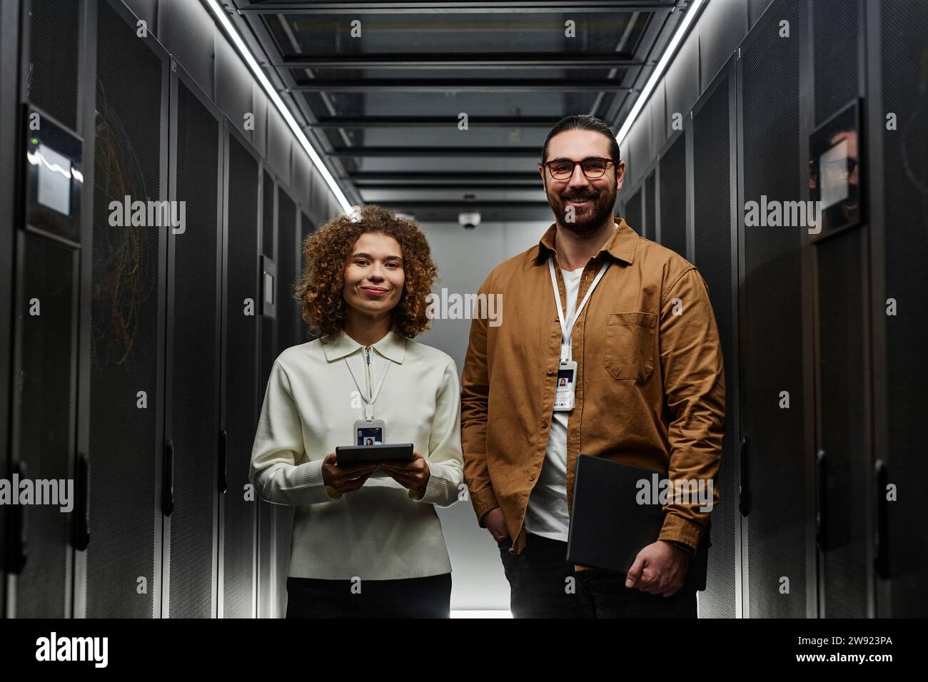 Smiling IT engineers standing in server room Stock Photo