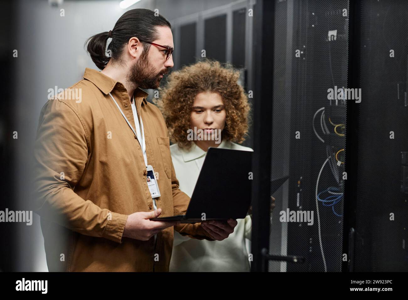 Young engineers checking servers with laptop in data center Stock Photo