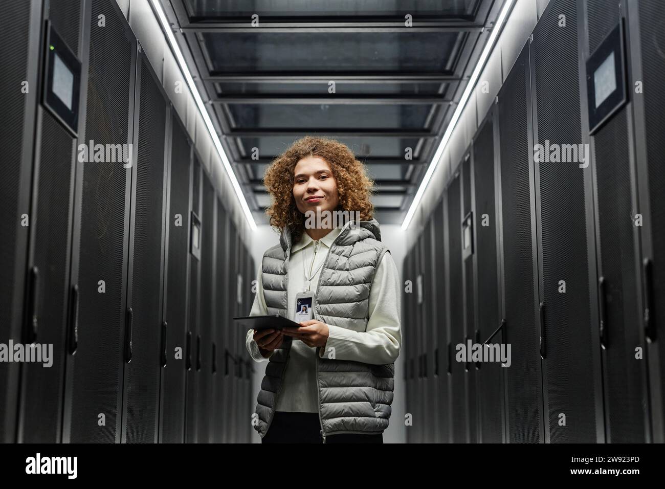 Smiling engineer with tablet PC standing in server room Stock Photo