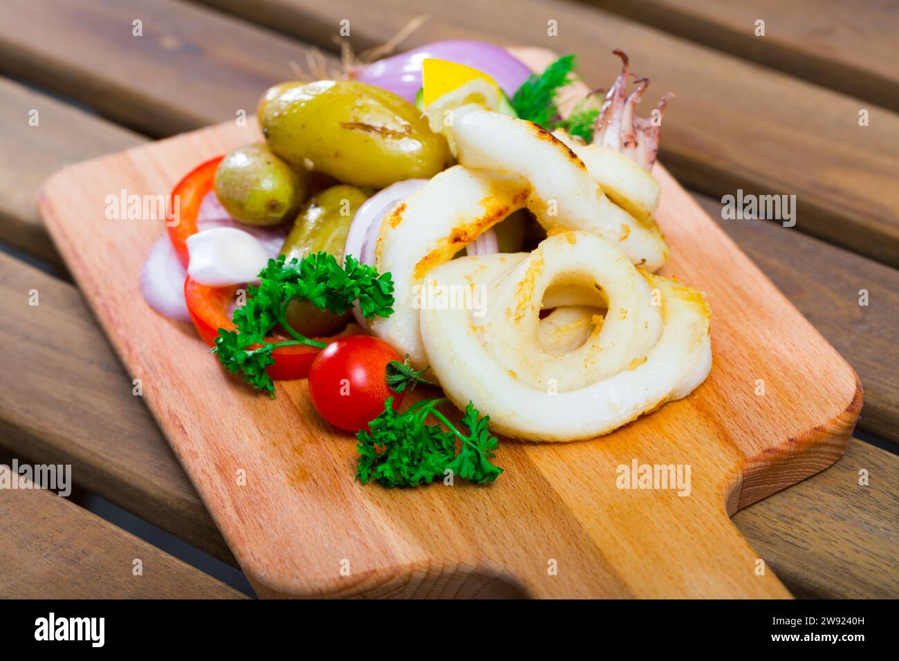 Baked squid rings with potatoes and vegetables Stock Photo - Alamy
