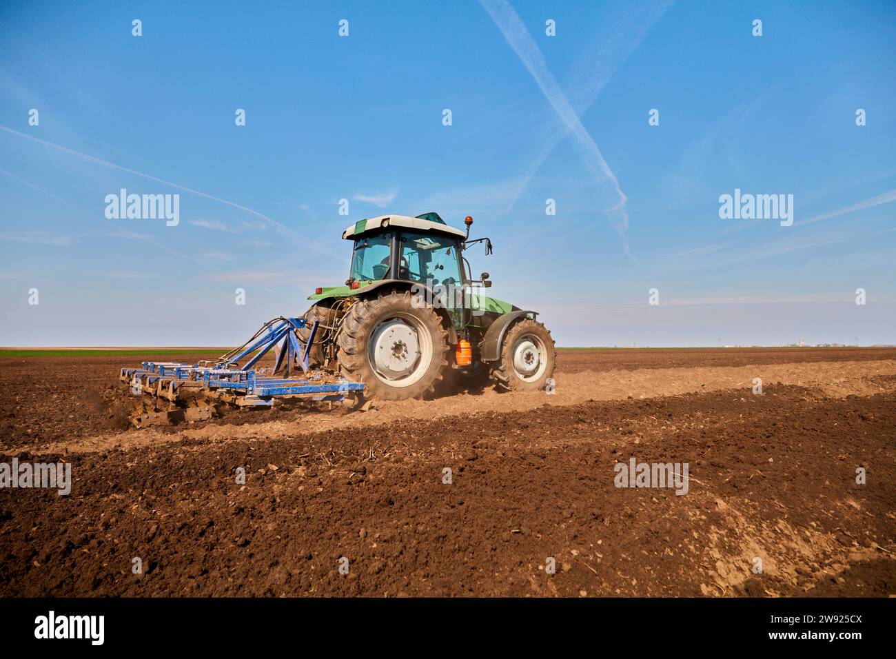 Tractor plowing field in early spring Stock Photo