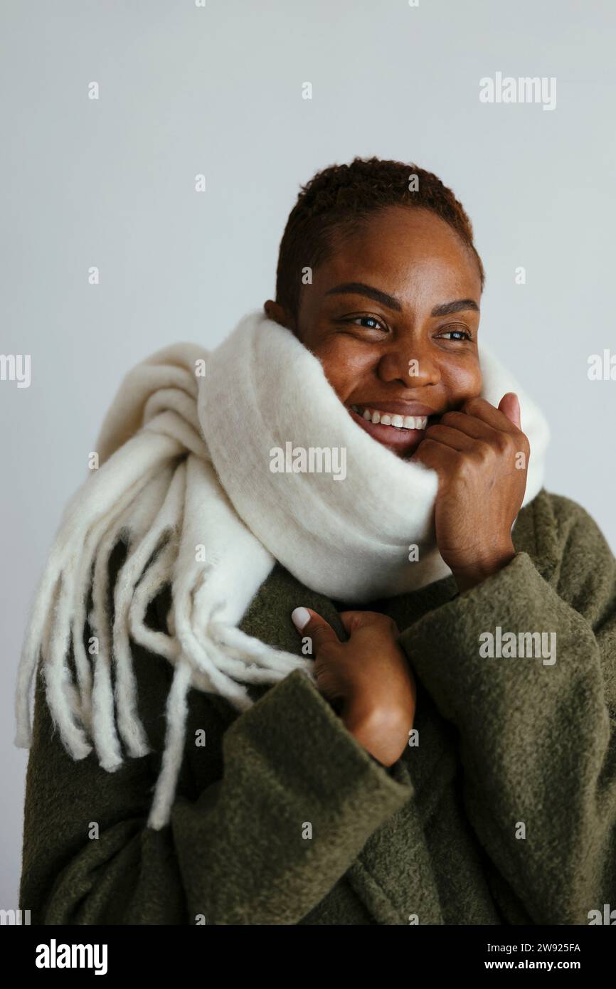 Smiling woman wearing scarf against white background Stock Photo