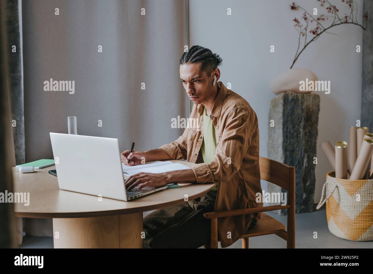 Dedicated young man using laptop learning through online tutorial at home Stock Photo