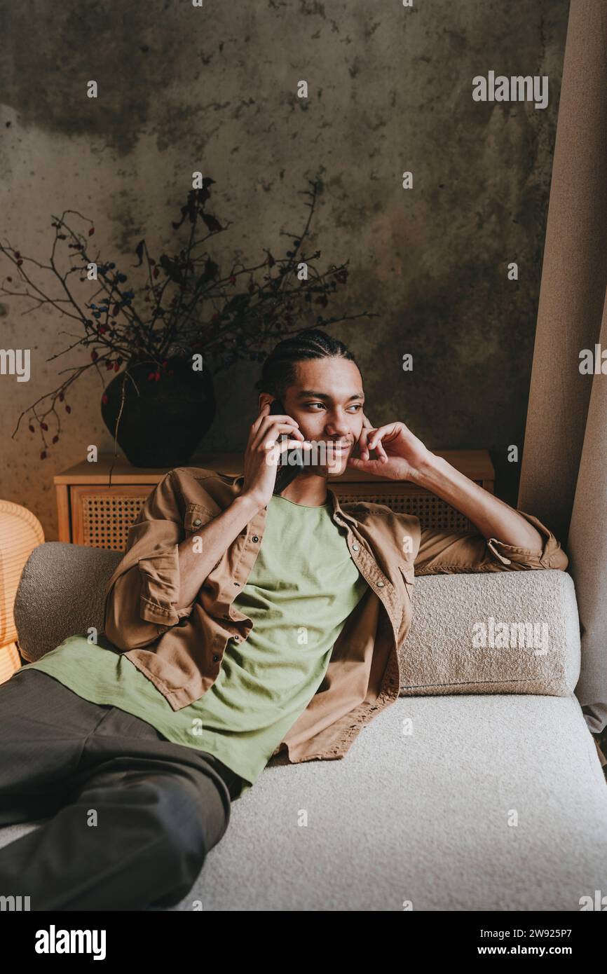 Young man sitting comfortably hi-res stock photography and images - Alamy