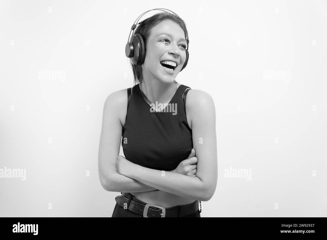 Portrait of a laughing woman in headphones. Musical accessories concept. Mixed media Stock Photo