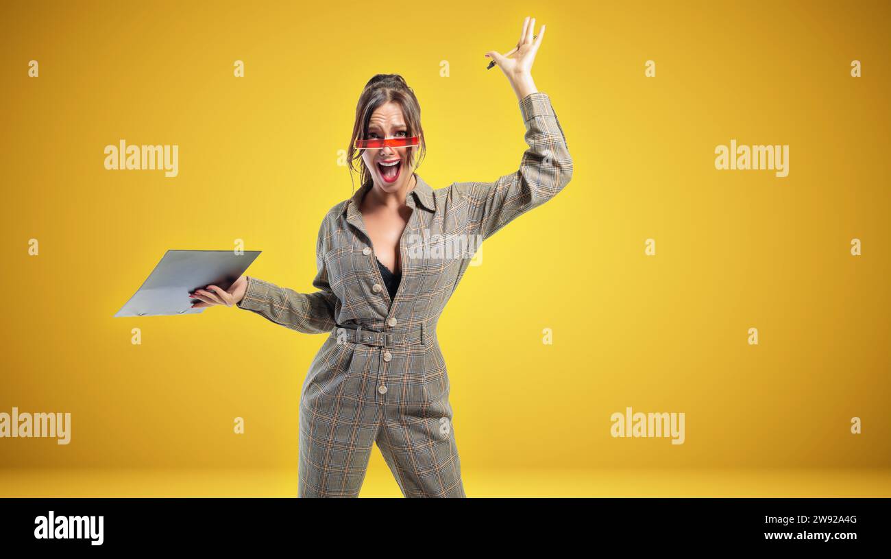 Portrait of a woman in a suit with a tablet. She waves her hand emotionally. Sports betting concept. Mixed media Stock Photo