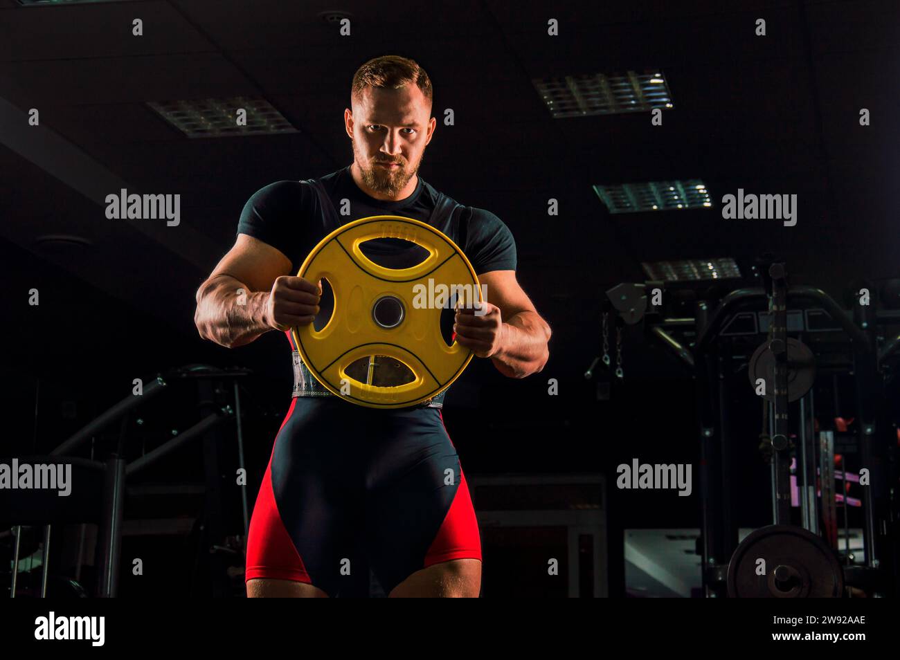Huge weightlifter stands with a weight for the bar in the gym Stock