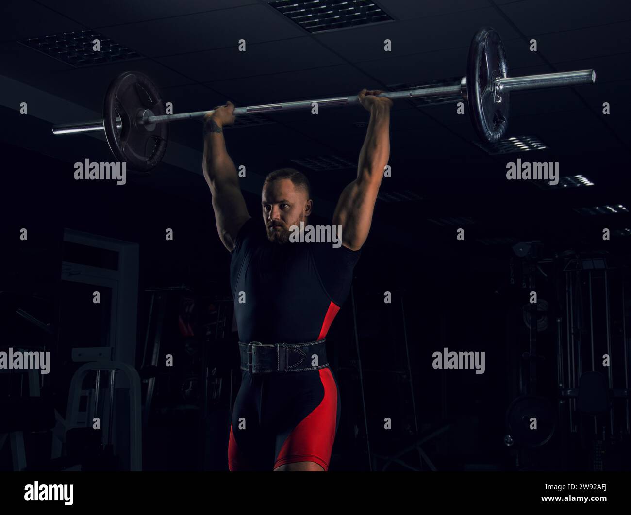Weightlifter lifts the bar above his head. Strength training with a