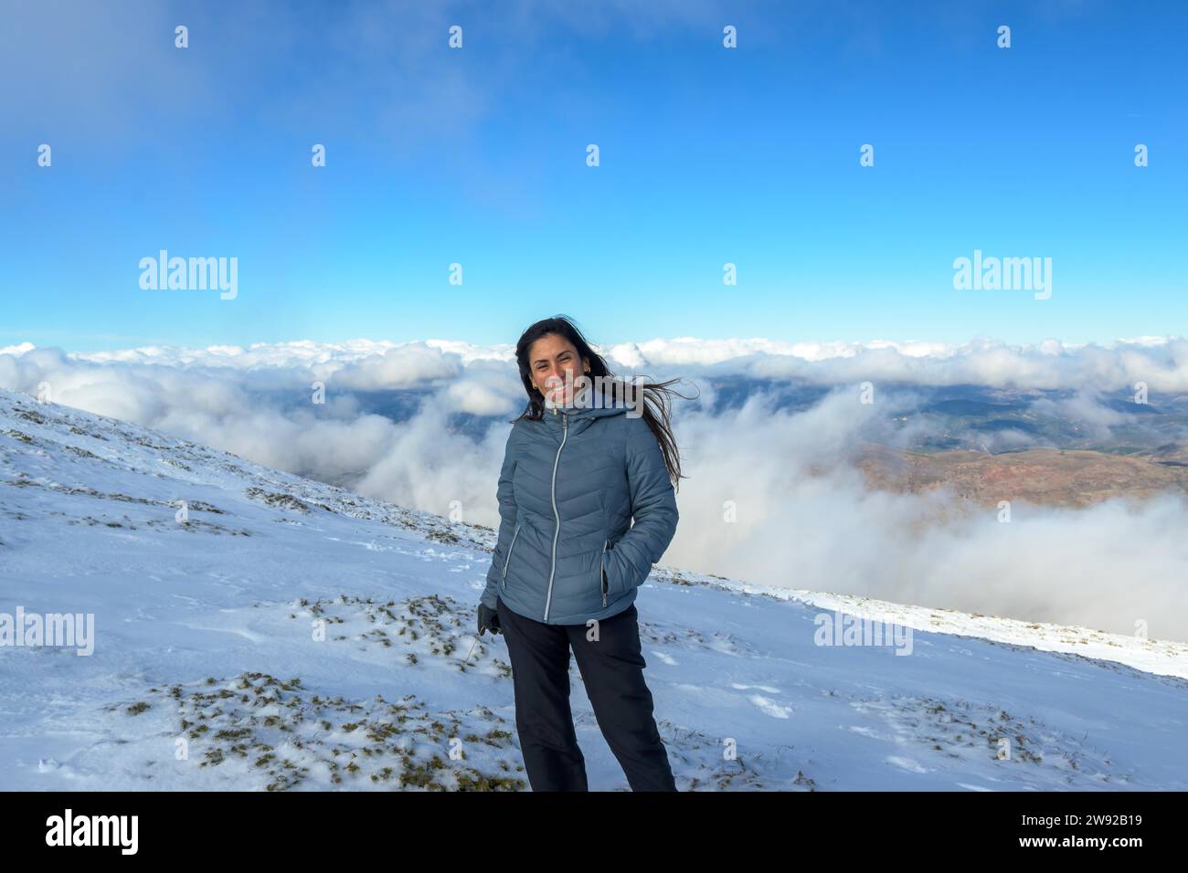 Portrait of latina woman in the snow above the clouds Stock Photo