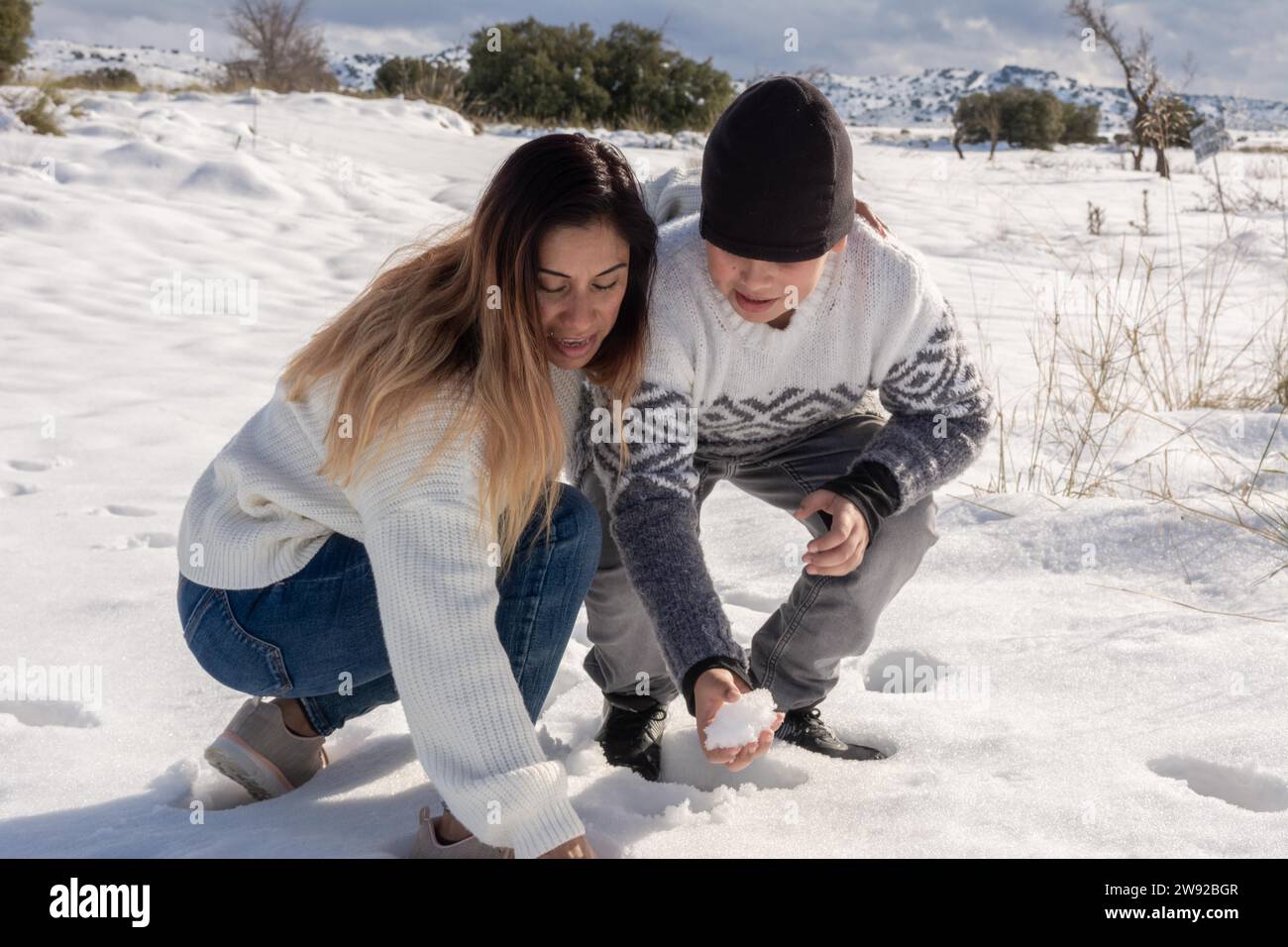 Mother and son playing with snowballs in snowy field Stock Photo - Alamy