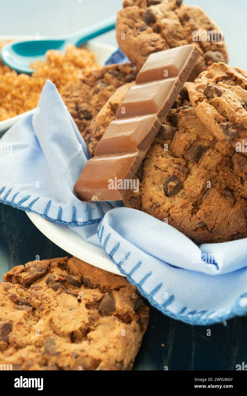 Close-up of chocolate chip cookies and a chocolate bar on a blue napkin, Delicious chocolate cookies Stock Photo
