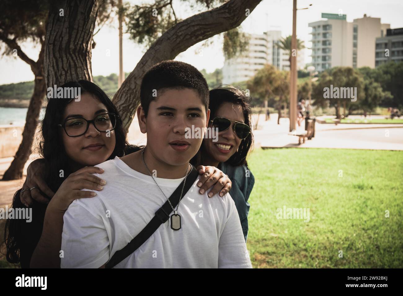 Cheerful group of young Latinos smiling at the camera in the open air, family portrait on a sunny day in the open air park Stock Photo