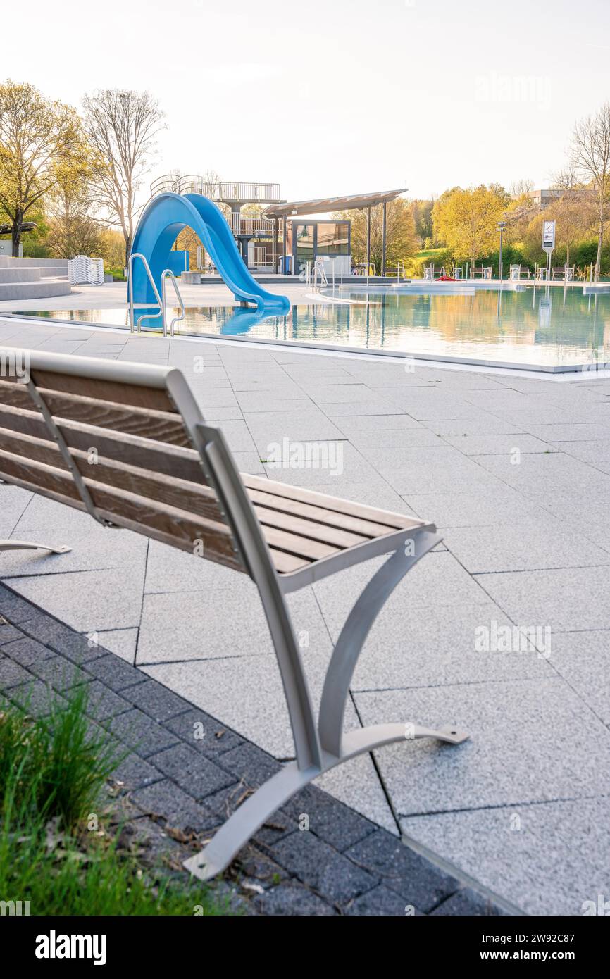 Lonely bench next to an empty swimming pool near a slide and clear ...