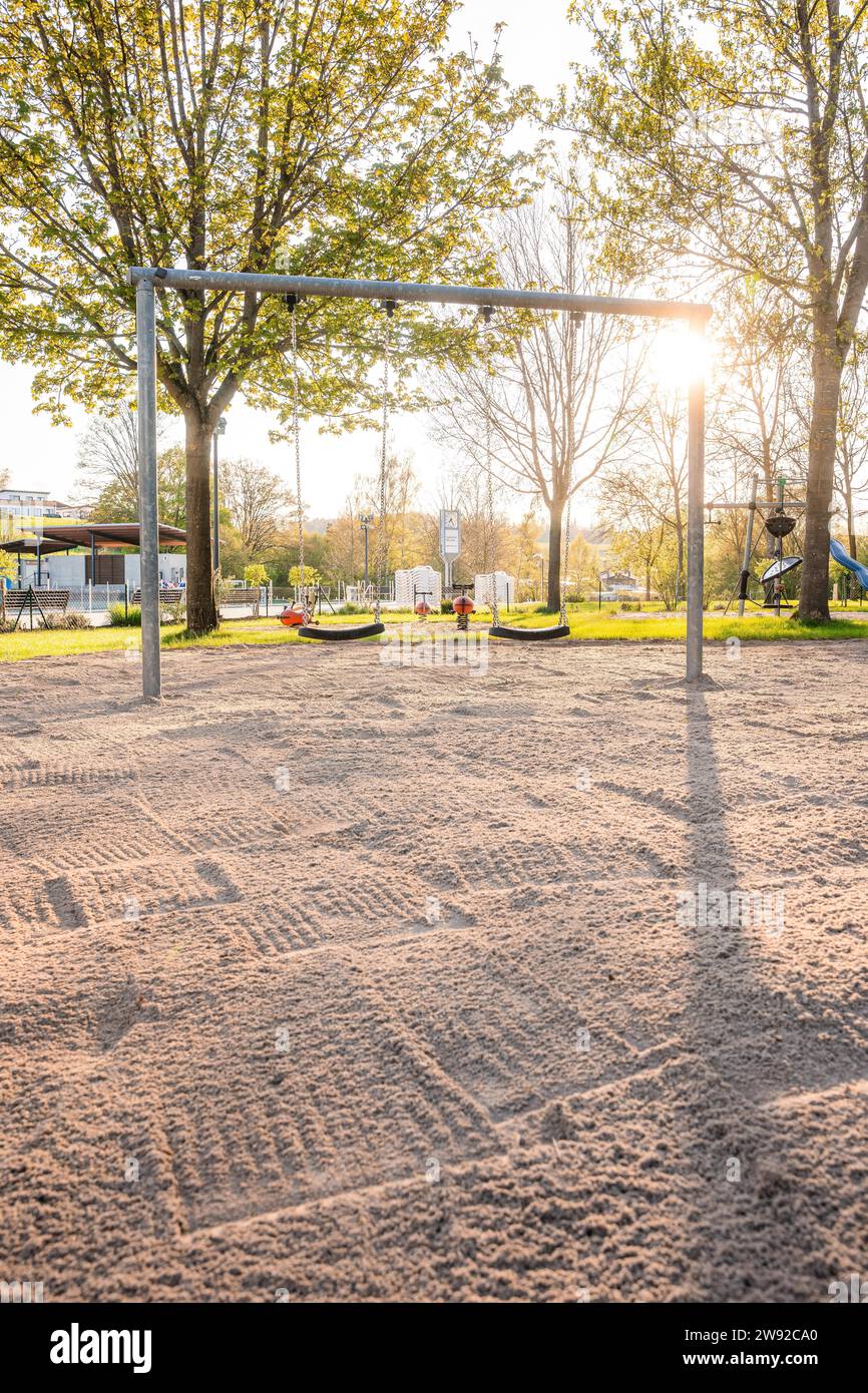 Sunny playground with swings and sandy area, surrounded by trees, Calw outdoor pool, Stammheim of the Calw public utility company, Black Forest Stock Photo