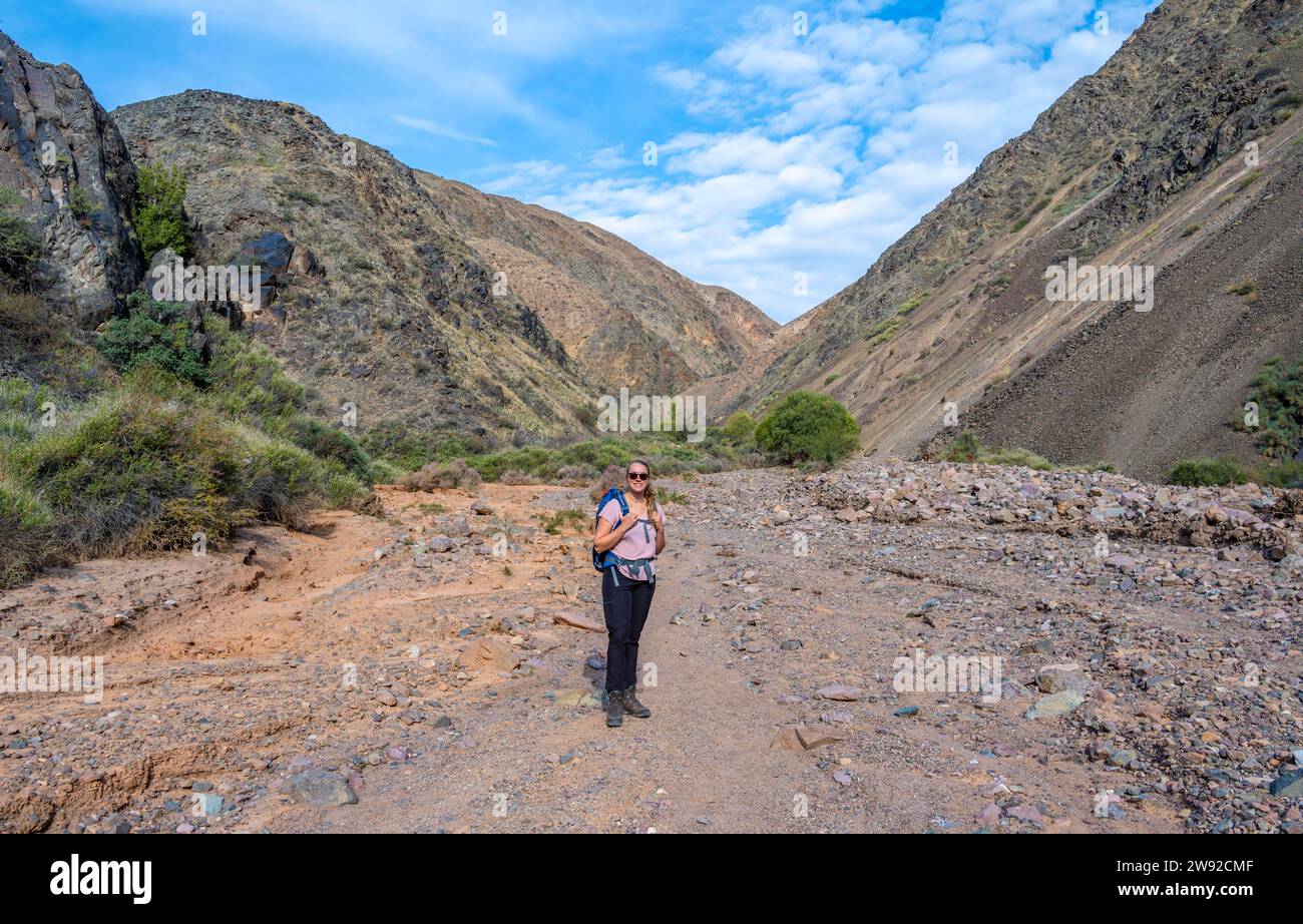 Mountaineer in a canyon with a dry stream bed, mountain landscape, Konorchek Canyon, Chuy, Kyrgyzstan Stock Photo