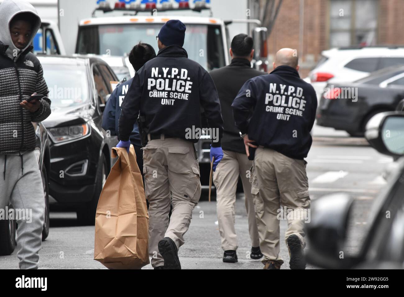 NYPD Officers from the Crime Scene Unit carry out large evidence bags from the apartment complex. Authorities were seen gathering evidence and working at the scene of a police involved shooting in the Bronx, Saturday afternoon in the area of Creston Avenue and Minerva Place. Two officers responded to 2865 Creston Avenue, 13th Floor, Apartment G and were met by a 19-year-old female with slice wounds to her facial area. Suspect was holding his mother in a headlock with a knife and officers fatally shot the suspect after he refused to drop the weapon. Stock Photo
