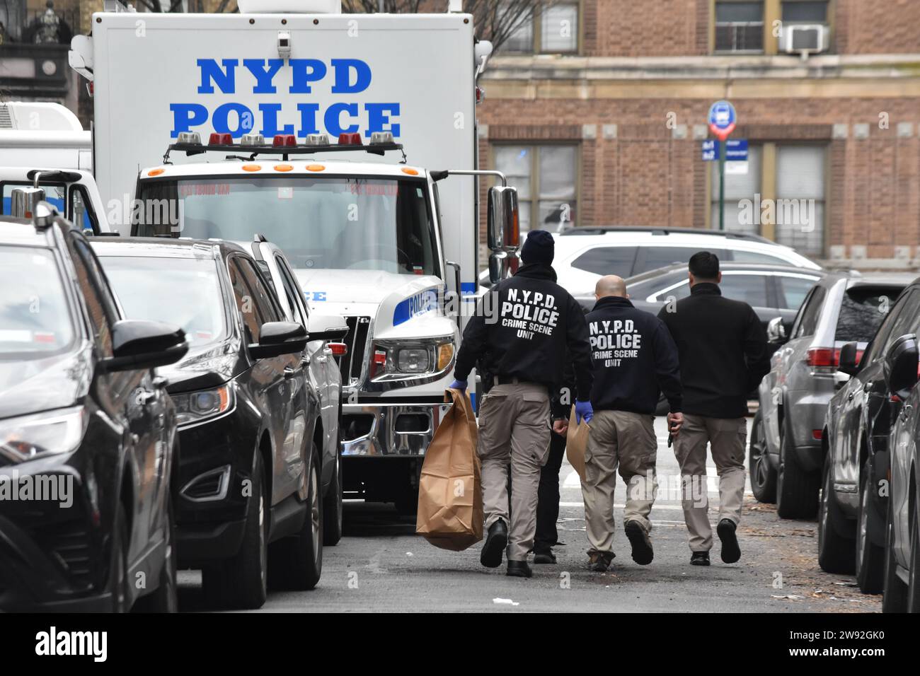 NYPD Officers from the Crime Scene Unit carry out large evidence bags from the apartment complex. Authorities were seen gathering evidence and working at the scene of a police involved shooting in the Bronx, Saturday afternoon in the area of Creston Avenue and Minerva Place. Two officers responded to 2865 Creston Avenue, 13th Floor, Apartment G and were met by a 19-year-old female with slice wounds to her facial area. Suspect was holding his mother in a headlock with a knife and officers fatally shot the suspect after he refused to drop the weapon. Stock Photo