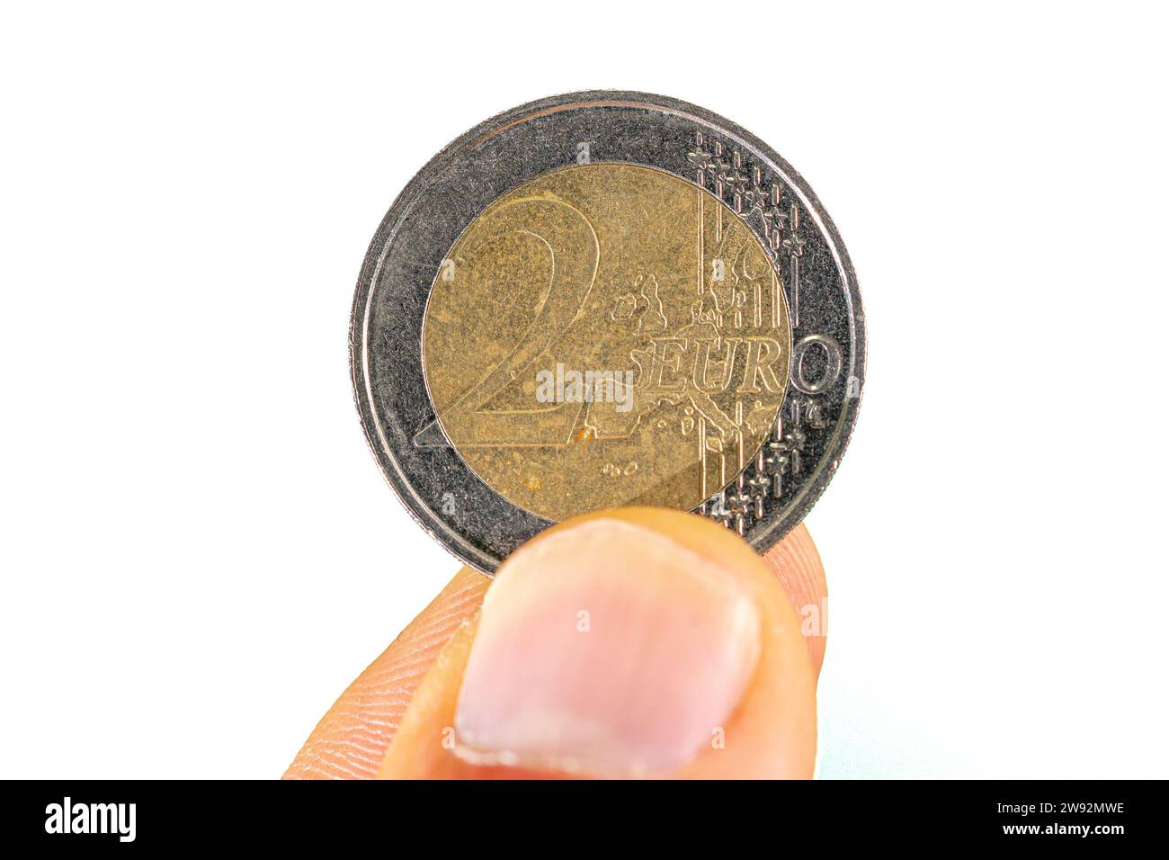 2 euro coin face held between thumb and index finger Stock Photo