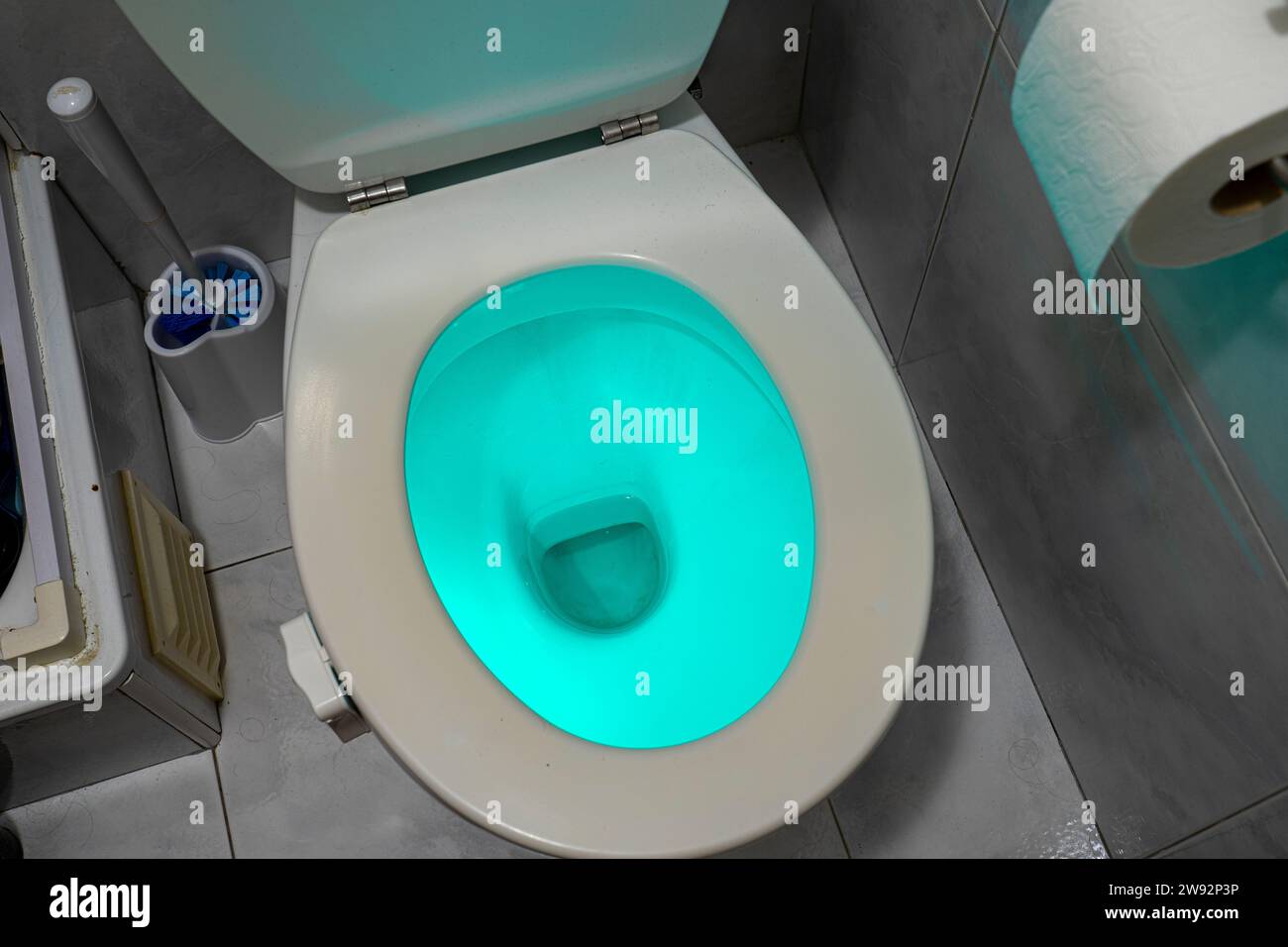 toilet illuminated with blue light inside by means of a device
