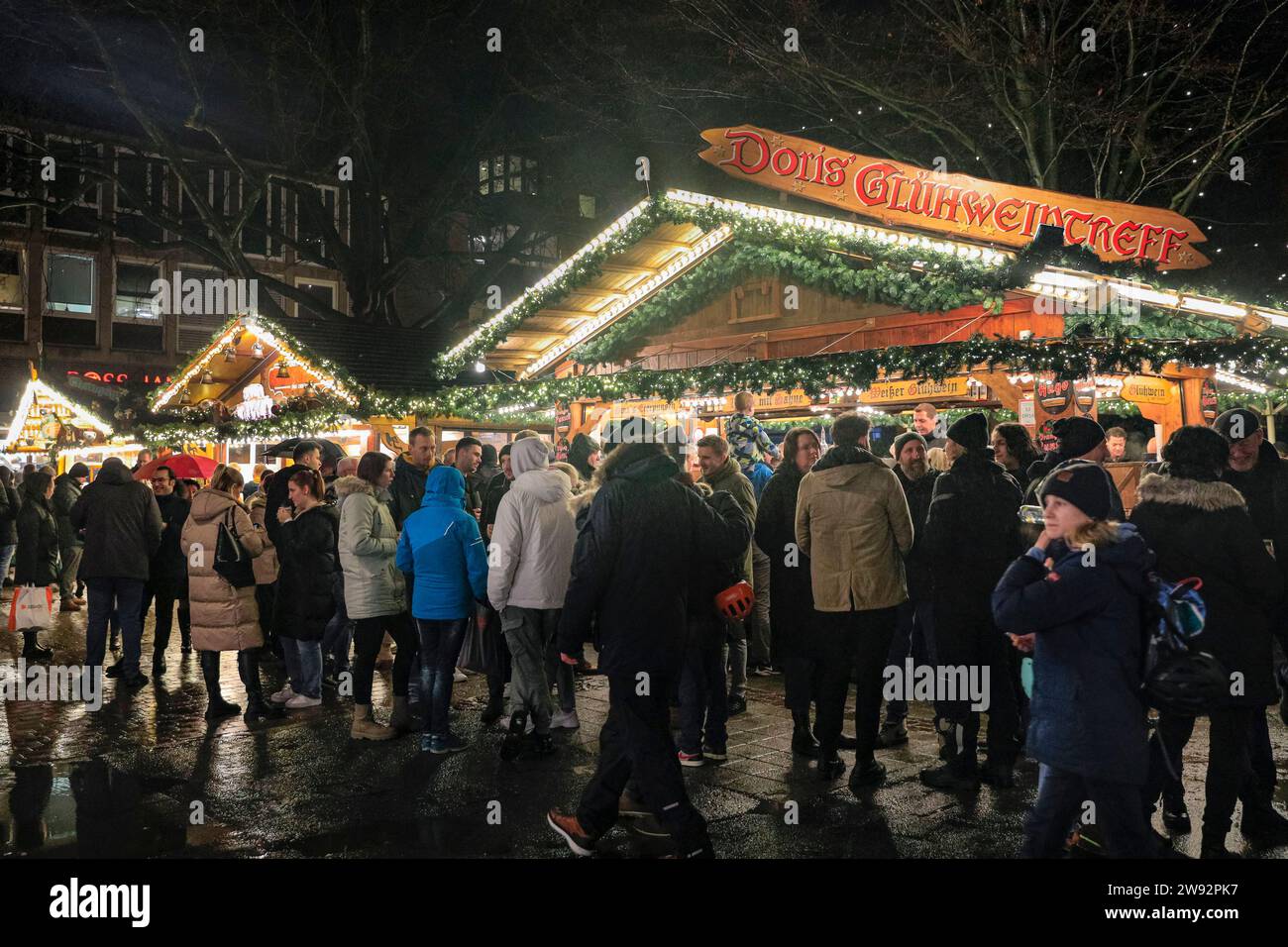 Münster, NRW, Germany. 23rd Dec, 2023. Shoppers stop for mulled wine on one of the city's six Christmas markets, open for the last day today. Christmas shoppers and tourists stroll along the pretty, medieval Prinzipalmarkt street in Münster's old town on a rainy last shopping day before Christmas Eve. Credit: Imageplotter/Alamy Live News Stock Photo