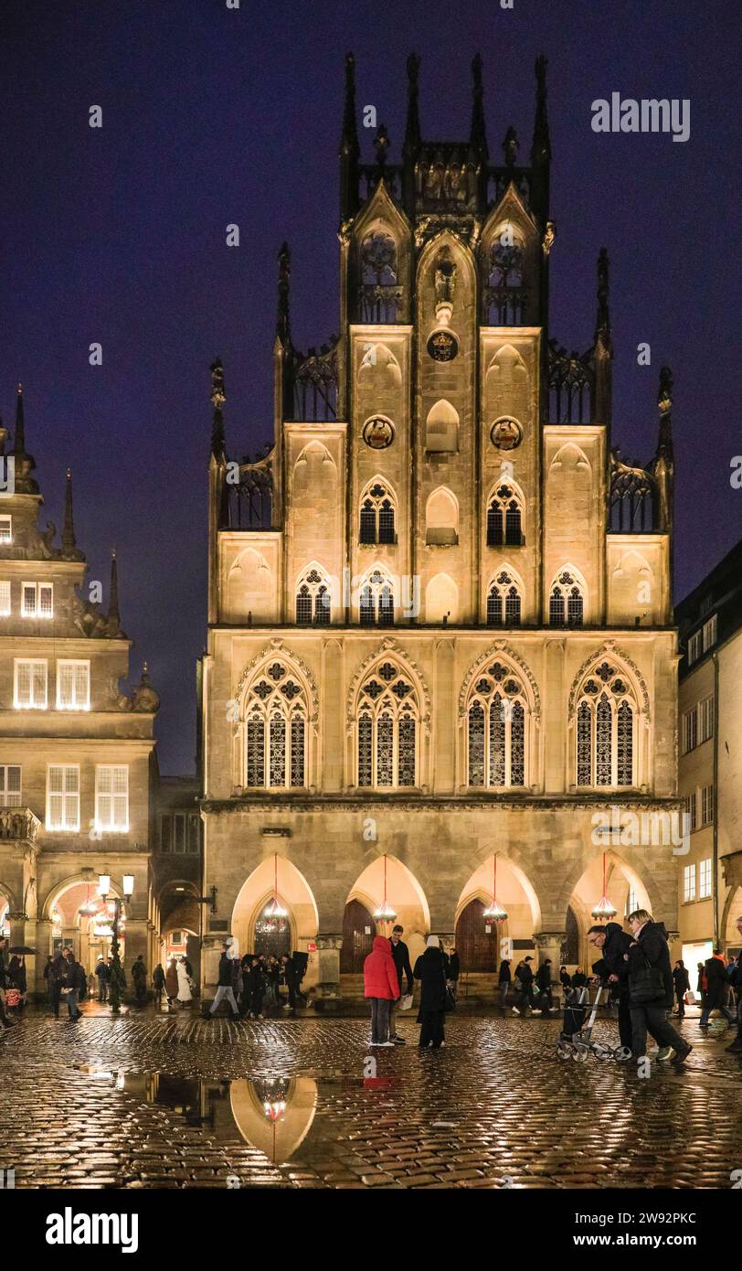 Münster, NRW, Germany. 23rd Dec, 2023. Christmas shoppers and tourists stroll past Münster's landmark 14th century town hall, site of the Peace of Westphalia Treaty treaty in the historic gothic architecture old town on a rainy last shopping day before Christmas Eve. Credit: Imageplotter/Alamy Live News Stock Photo
