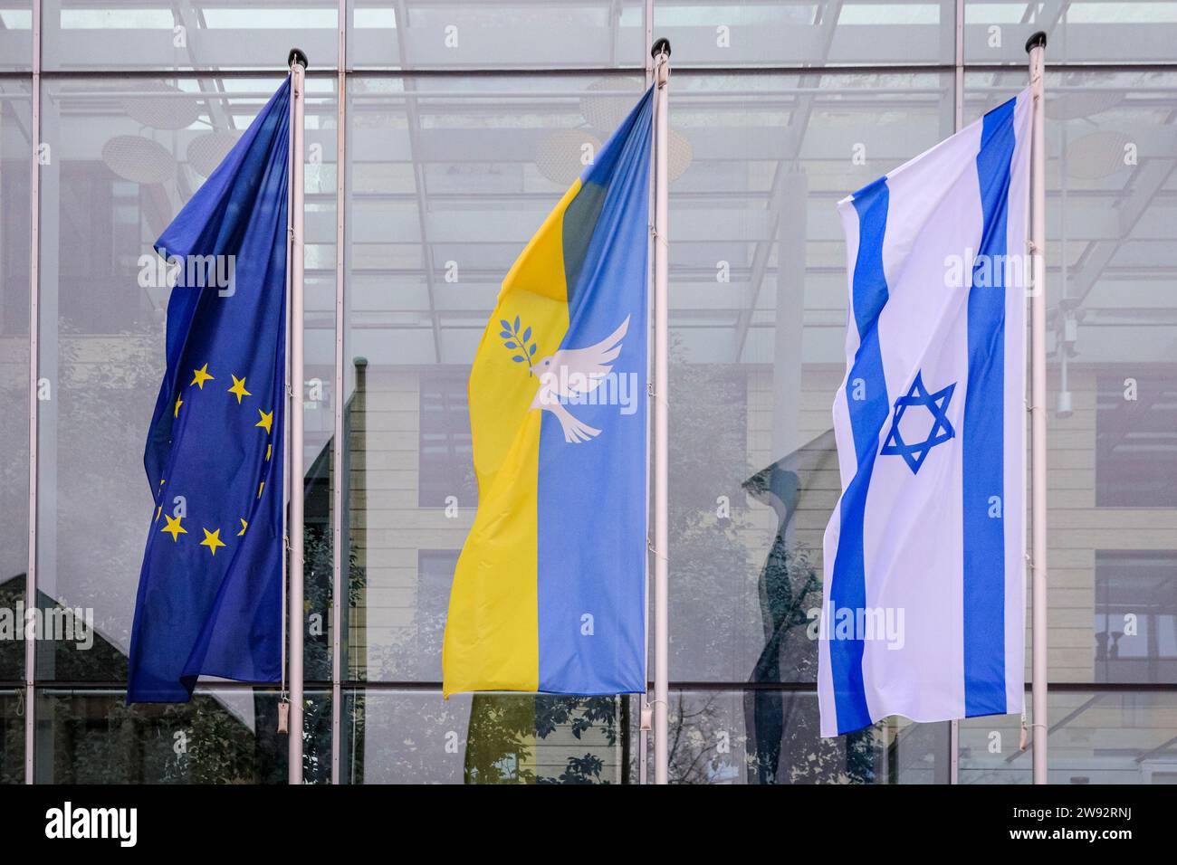 Münster, NRW, Germany. 23rd Dec, 2023. Three flags fly outside the Münster District Authority regional government offices (left to right) a EU flag, a Ukraine Peace flag (with a white dove) and the flag of Israel, in solidarity with both countries and as a symbol of peace. Credit: Imageplotter/Alamy Live News Stock Photo