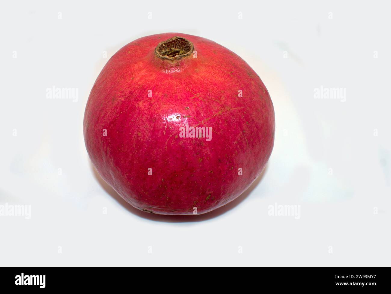 Single bright red pomegranate fruit, also known as Chinese apple, on a plain white background -01 Stock Photo