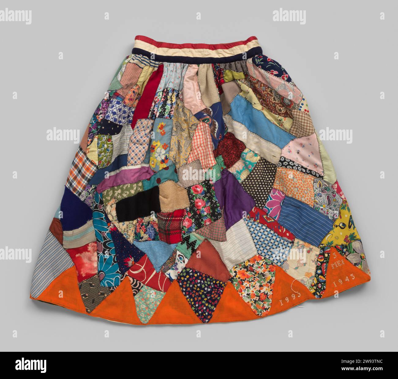 National party skirt Mrs. Brand, 1945 - 1951  Skirt with red, white, blue waistband and orange triangles made from a pennant at the bottom. The skirt is sewn on an old green curtain. The patches of fabric come from various items of clothing from the family of Mrs. Brand and old curtains, blankets etc. Target textile materials   Rotterdam Stock Photo