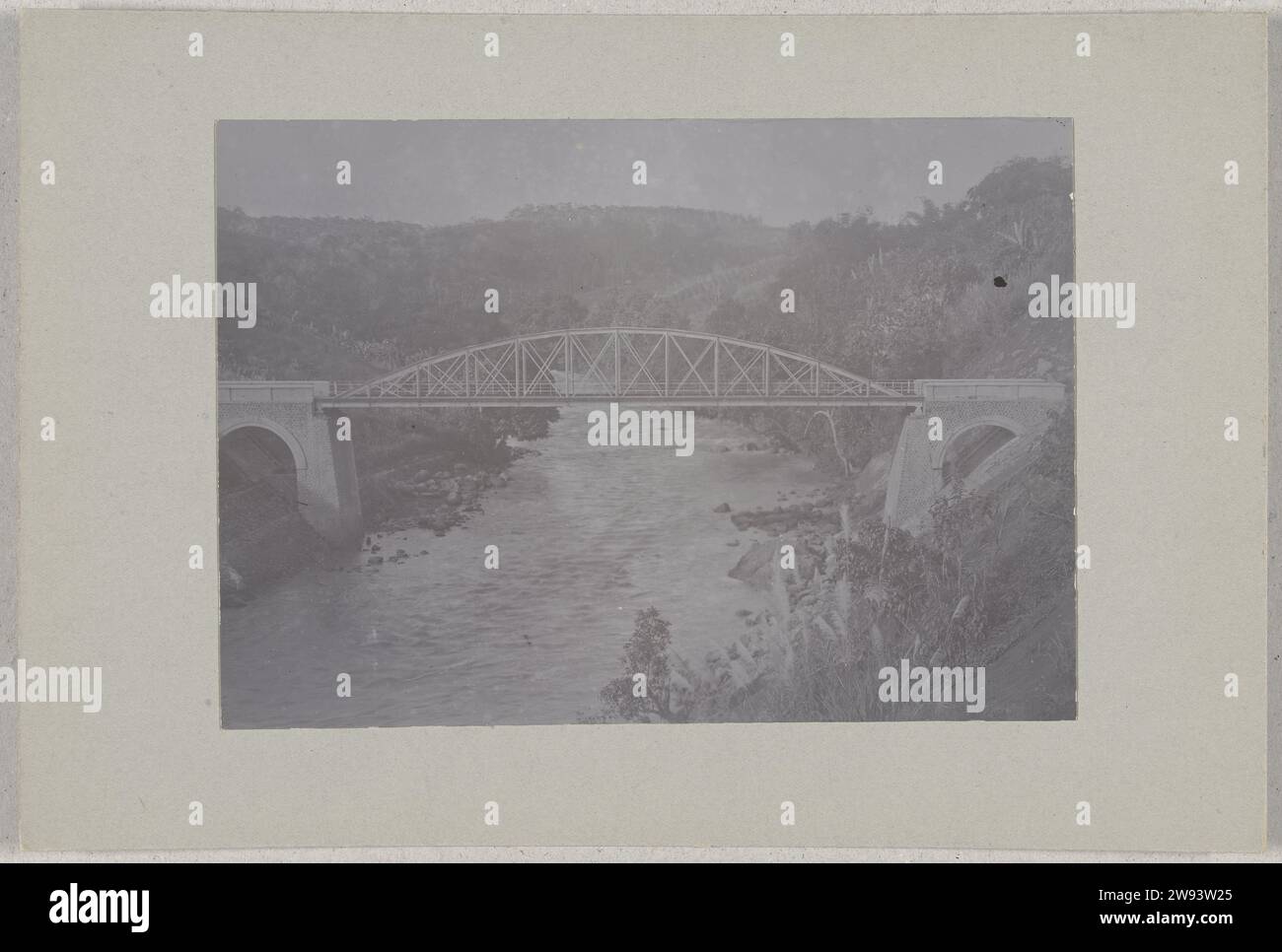 Bridge over a river, on its way to the wine merchant bay on Java, c. 1895 - c. 1915 photograph Bridge over a river, on its way to the wine merchant bay, Java, Dutch East Indies Java photographic support. paper. cardboard gelatin silver print  Indonesia Stock Photo