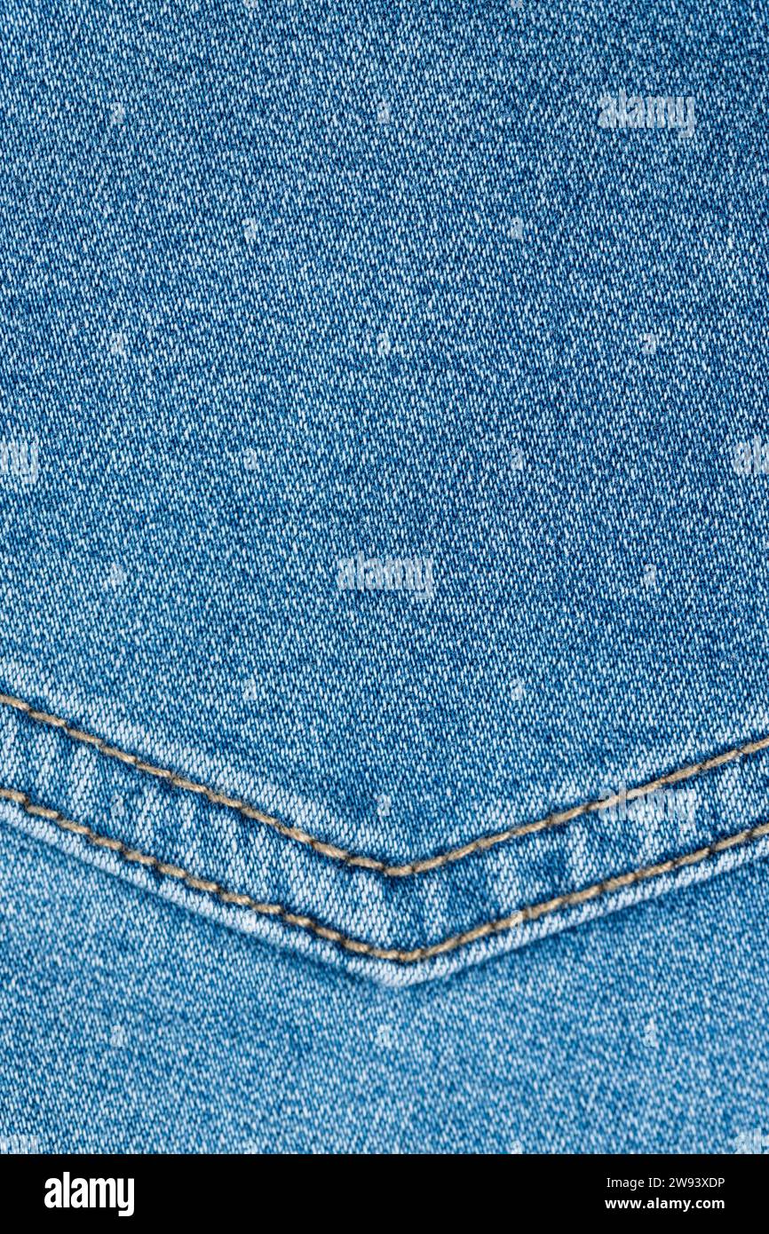 blue denim fabric made of cotton, details of a piece of clothing sewn from blue denim Stock Photo