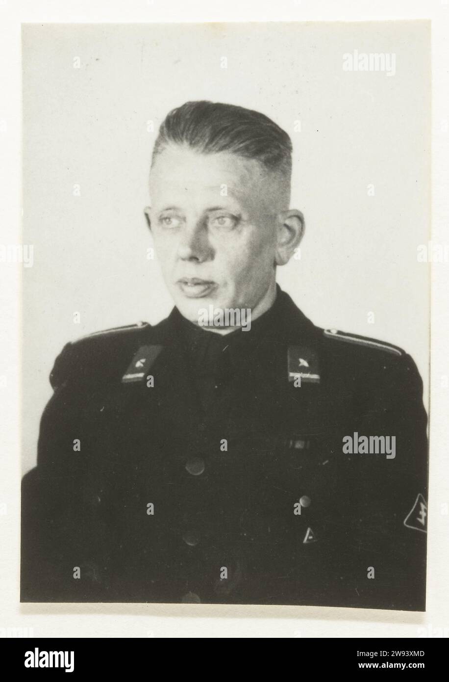 Portrait of a member of De Wa, 1940 - 1944 contact print Portrait of a member of the WA. On his collar a distinctive of a star with a line underneath: lower frame WA, Vaandrig. Braided shoulder covering, the Wolfsangel on his left sleeve. Barefoot. Netherlands photographic support gelatin silver print anonymous historical person portrayed Netherlands Stock Photo