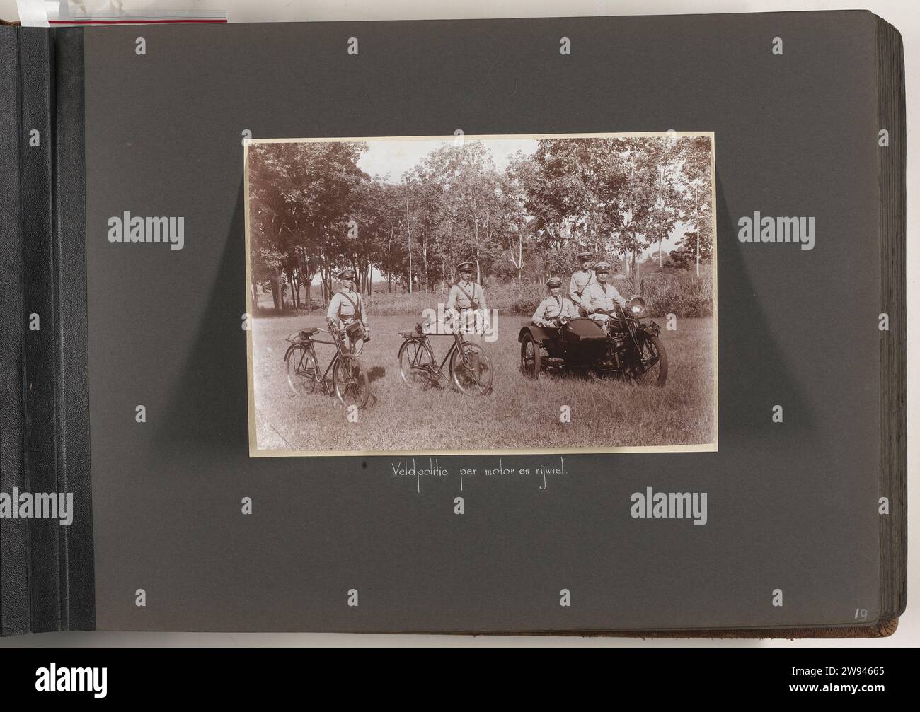 Field police by engine and bicycle, 1925 - 1931 photograph Album magazine with one photo: two agents with bicycles and three agents on a motor with sidecar of the field police in Batavia. Part of the photo album offered to S. Koster by the Association of Higher Police Civil servants in the Dutch East Indies in 1931. Batavia cardboard. photographic support   Dutch East Indies, The. Batavia Stock Photo
