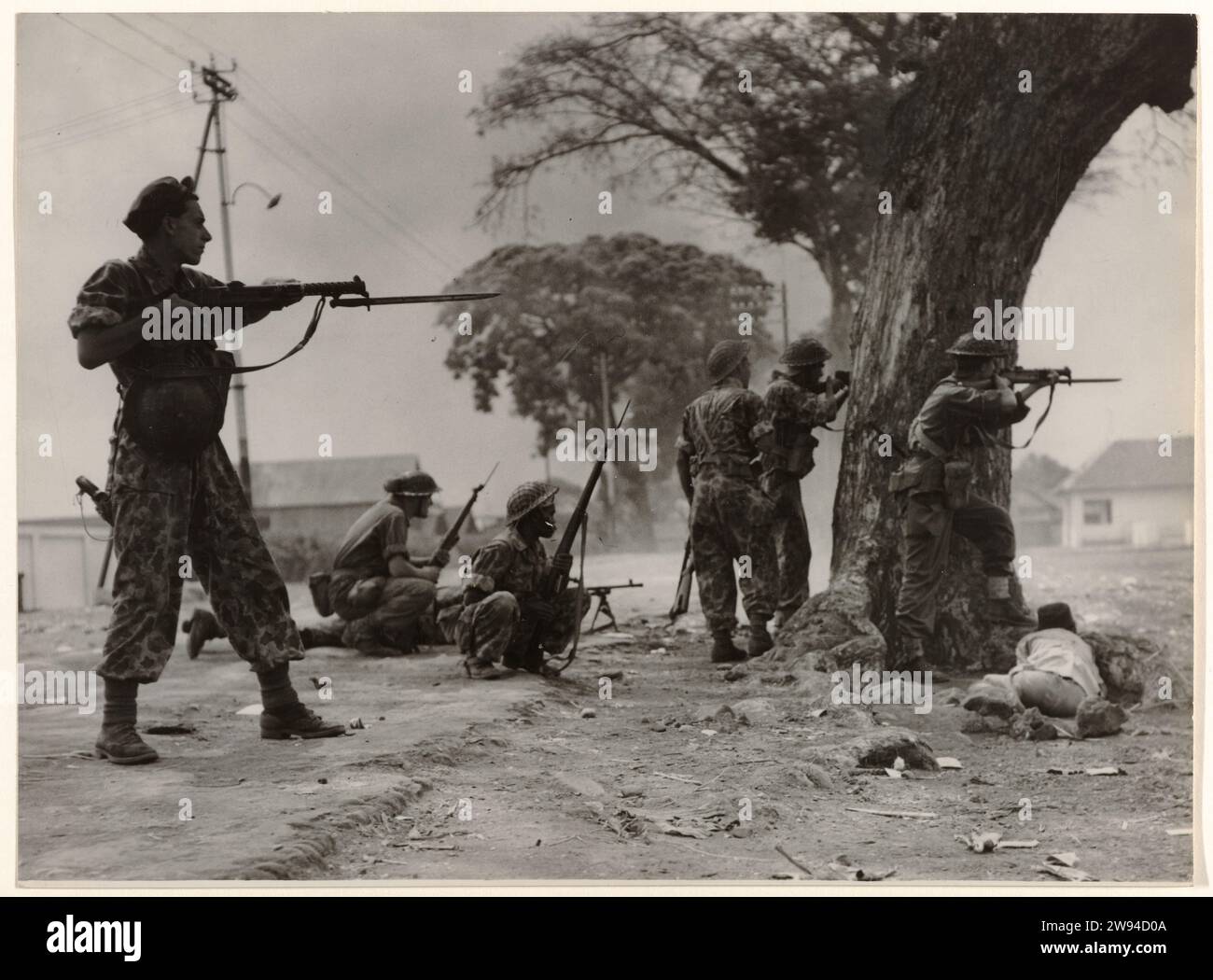 Dutch Soldiers Respond to Gunfire from a Sniper in Malang, Java, 1947 - 1949 photograph Dutch soldiers answer the fire of a sniper in Malang. Java photographic support  revolution, revolt. guerilla warfare Java. Dutch East Indies, The Stock Photo
