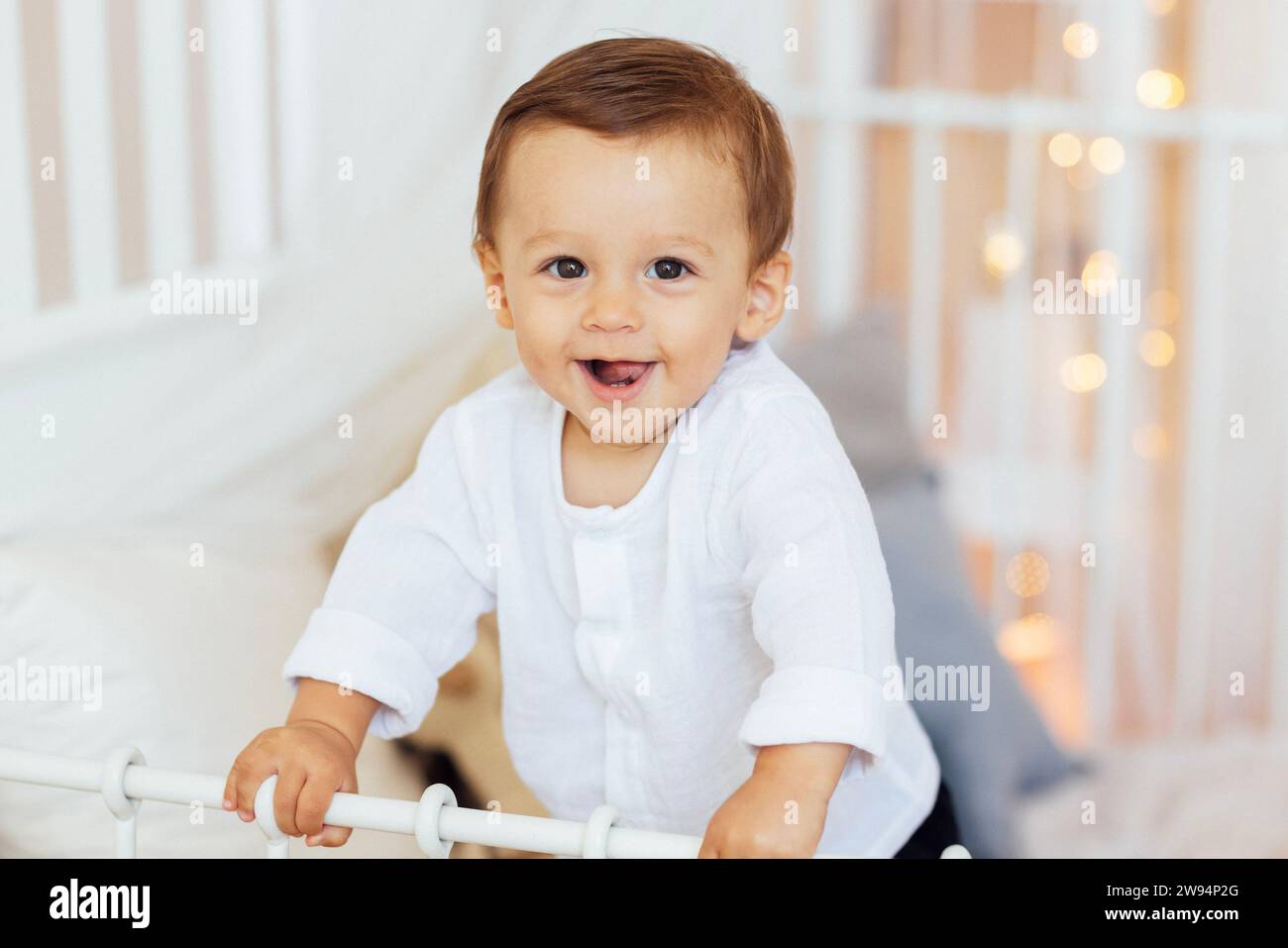 A little boy is playing in the living room. A sweet baby in a white ...