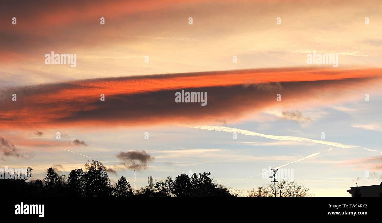 Cloud formations in the light of the setting sun Stock Photo