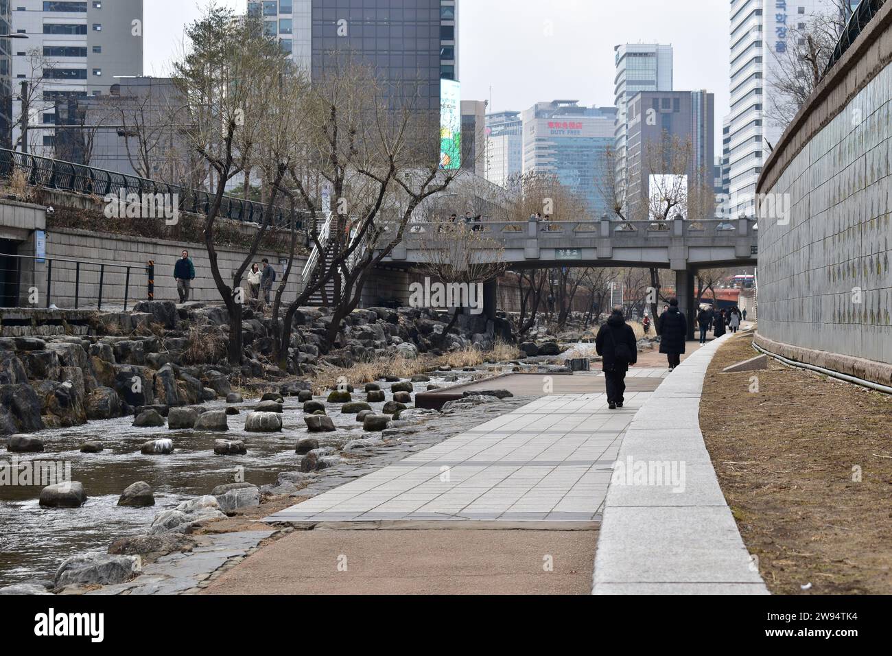 People walking in Cheonggyecheon park, an open water stream in downtown Seoul Stock Photo