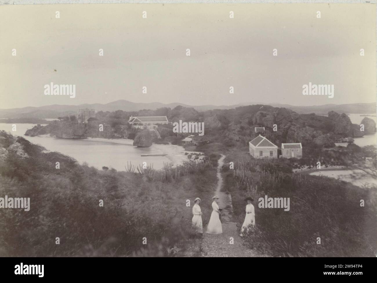 Caracas Bay, Andries August Boom, 1910 photograph Caracas Bay with the quarantine building, Curaçao, June 1910. Three women on the path. Part of the photo album of the Boom-Gonggrijp family in Suriname and Curaçao. Curaçao photographic support   Curaçao. Caracasbaai Stock Photo