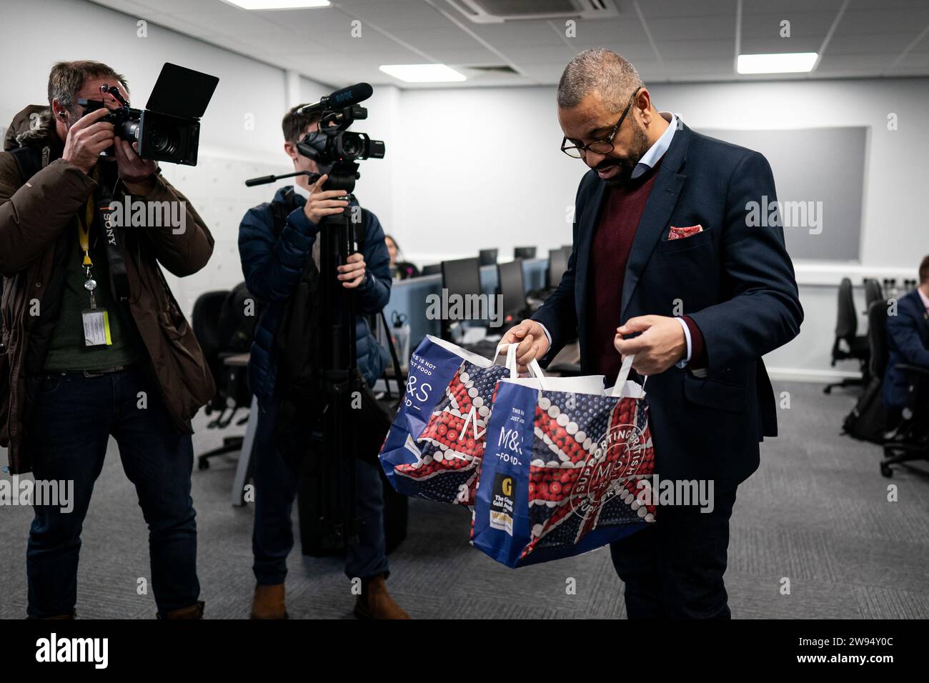 Home Secretary James Cleverly looks inside bags for mince pies and chocolates whilst meeting police officers at Luton Police Station to thank them for their service for working over the festive period. Picture date: Thursday December 21, 2023. Stock Photo